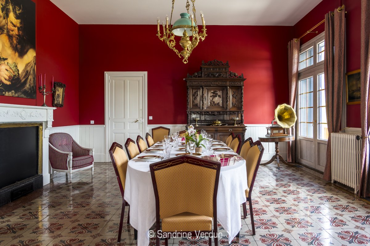 Salle à manger de prestige dans un château avec table dressée pour un dîner gastronomique