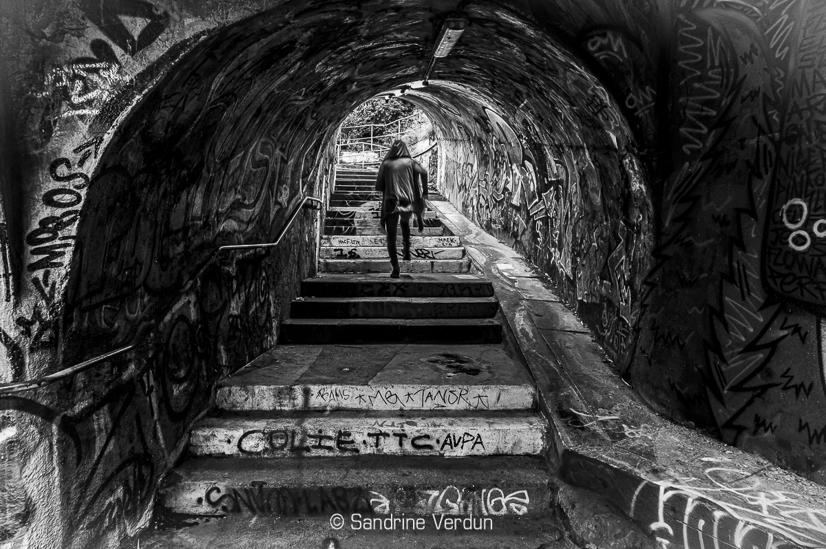 L'appel des abysses urbaines - Sandrine Verdun Photographie artistique en noir et blanc d'un homme courant dans un tunnel